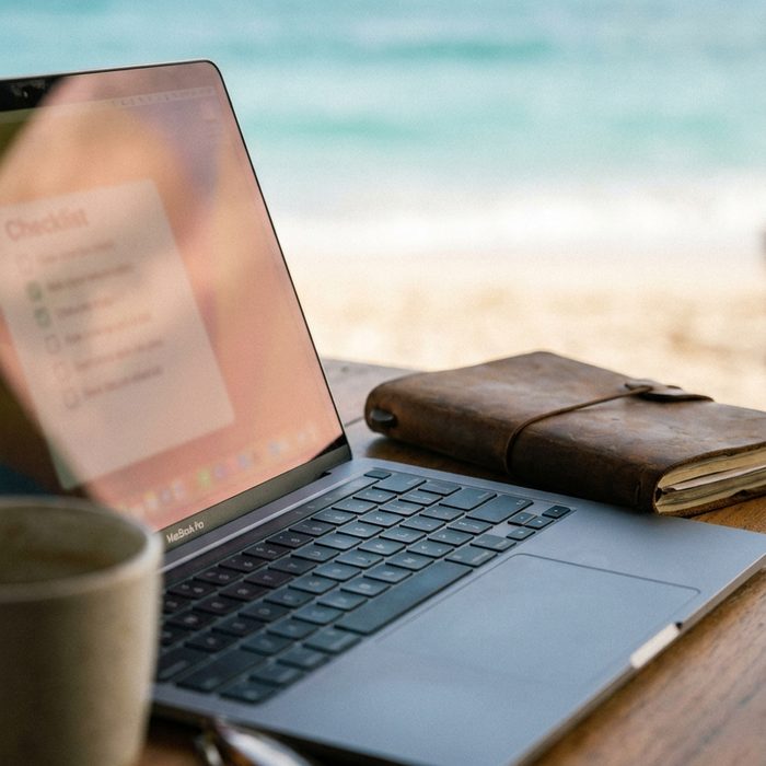 Geld verdienen mit einem Blog: Laptop und aufgeschlagenes Notizbuch nebeneinander