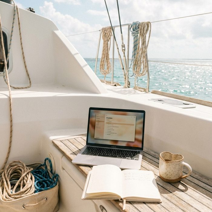 Content erstellen mit künstlicher Intelligenz: Arbeiten an Deck: Laptop und Notizbuch auf einem Boot